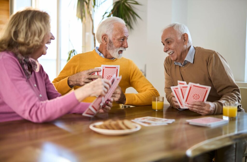 A group of happy seniors enjoys each other's company over a game of cards in their assisted living community.
4 of 6
