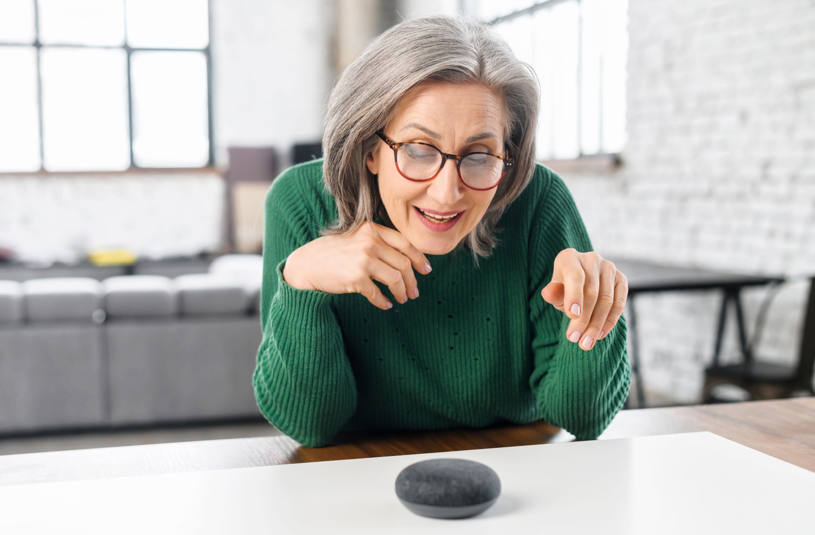 A smiling senior uses Amazon Alexa to play their favorite song.